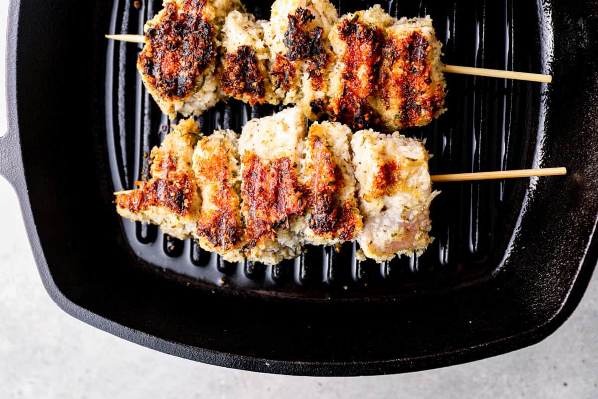 Chicken spiedini skewers cooking on a grill pan.