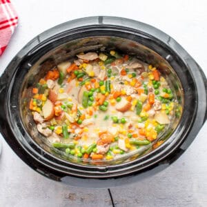 Crockpot filled with chicken pot pie ingredients.