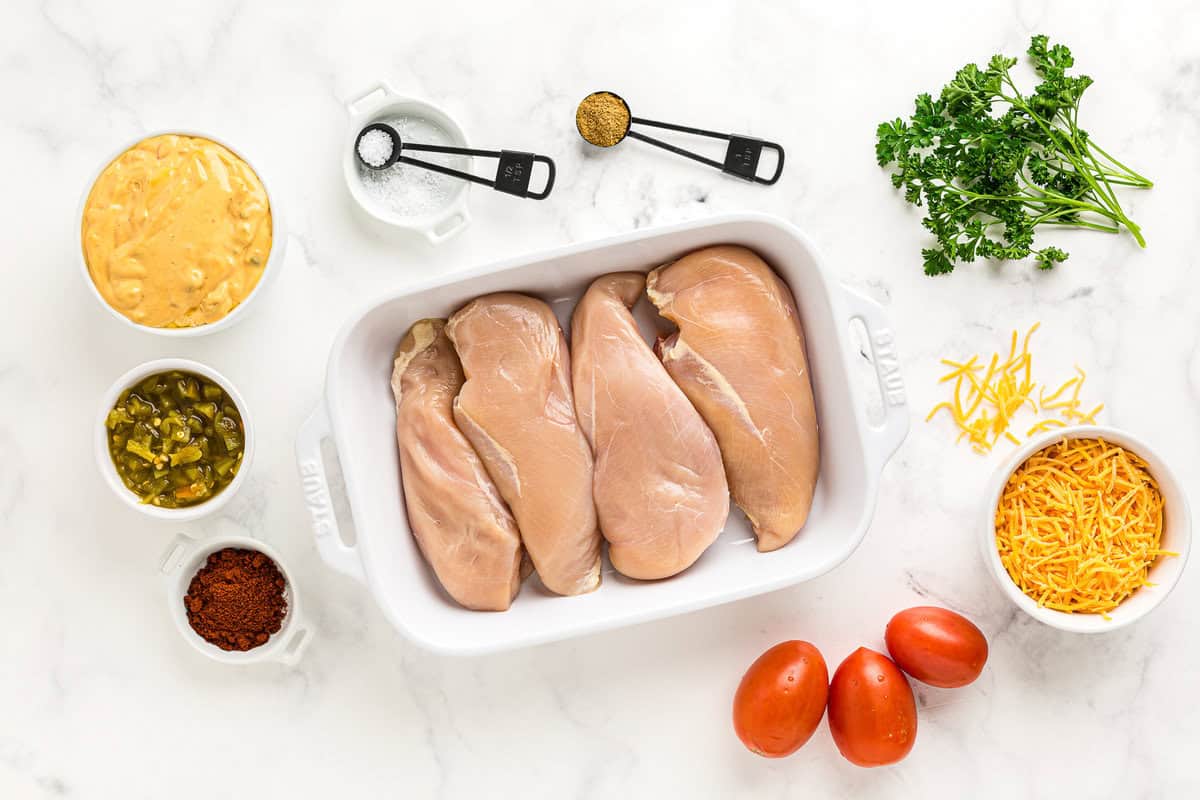 Ingredients for chicken con queso arranged on a marble countertop.