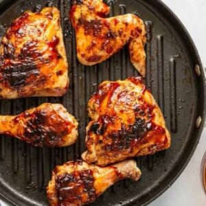 BBQ chicken cooking on a grill pan.