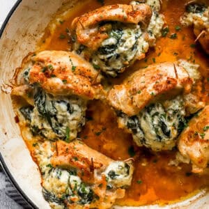 overhead view of stuffed chicken thighs in a skillet.