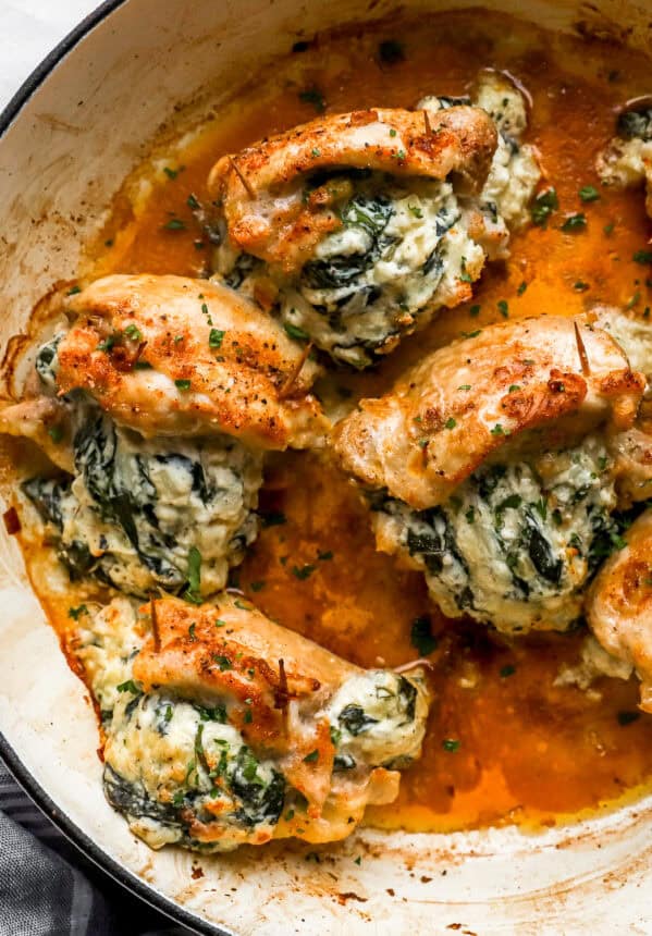 overhead view of stuffed chicken thighs in a skillet.