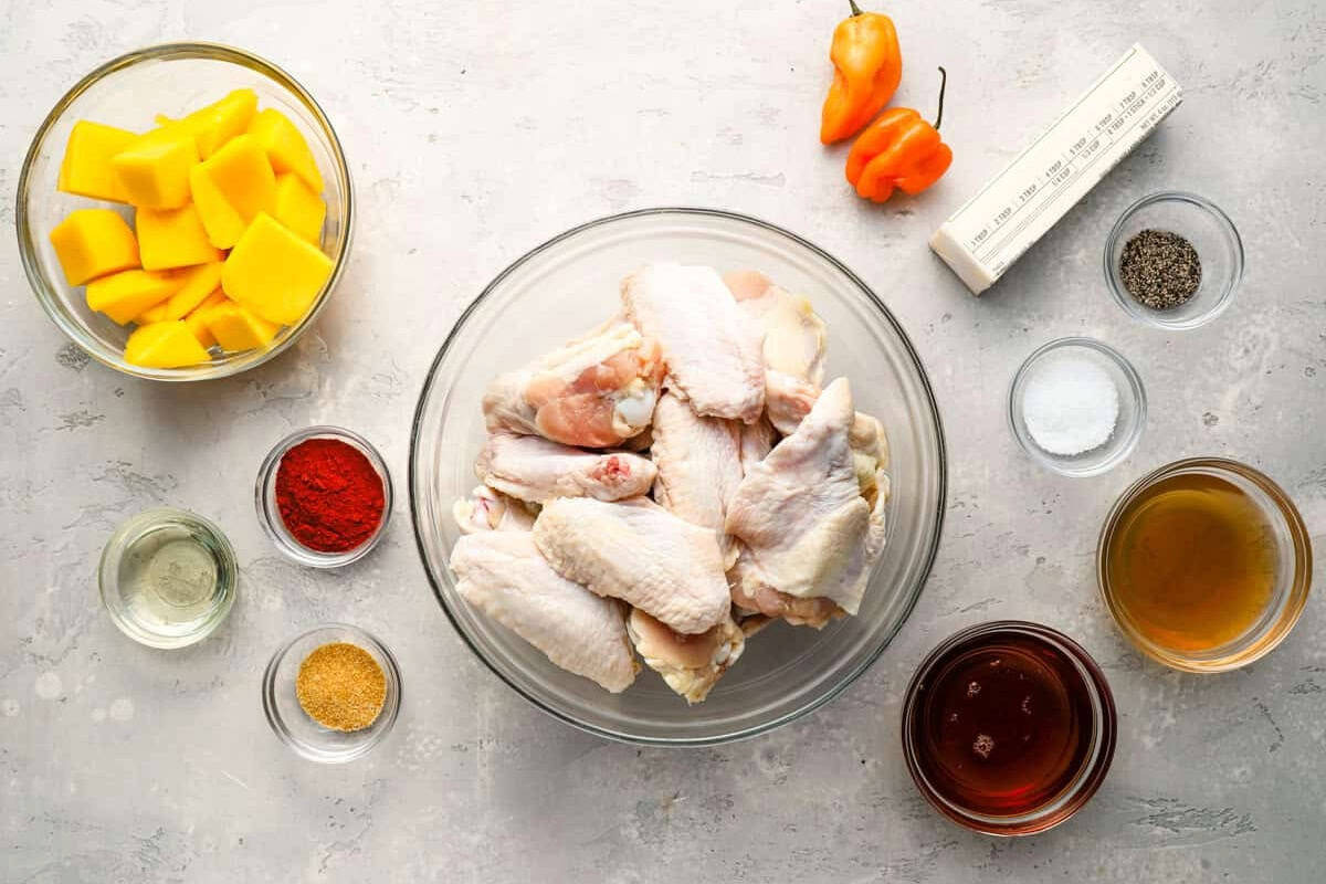 portioned ingredients for mango habanero wings in individual bowls.