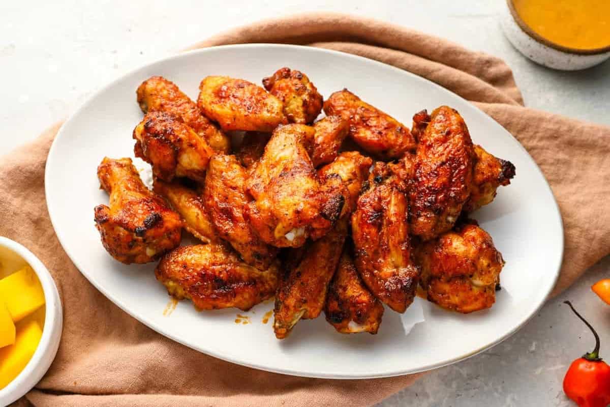 mango habanero chicken wings on a white oval platter.