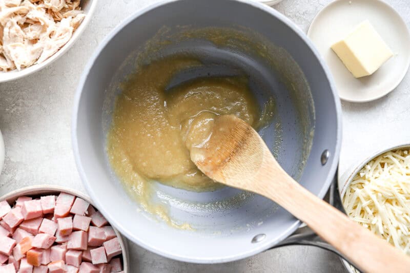 a roux in a pot with a wooden spoon.