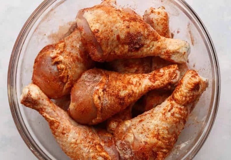 Pieces of chicken coated in a spice rub.