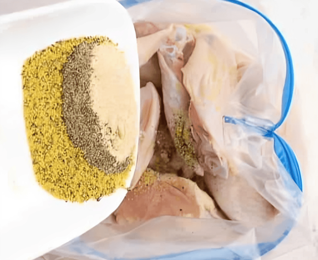 Adding lemon pepper seasonings to a bag with chicken wings.