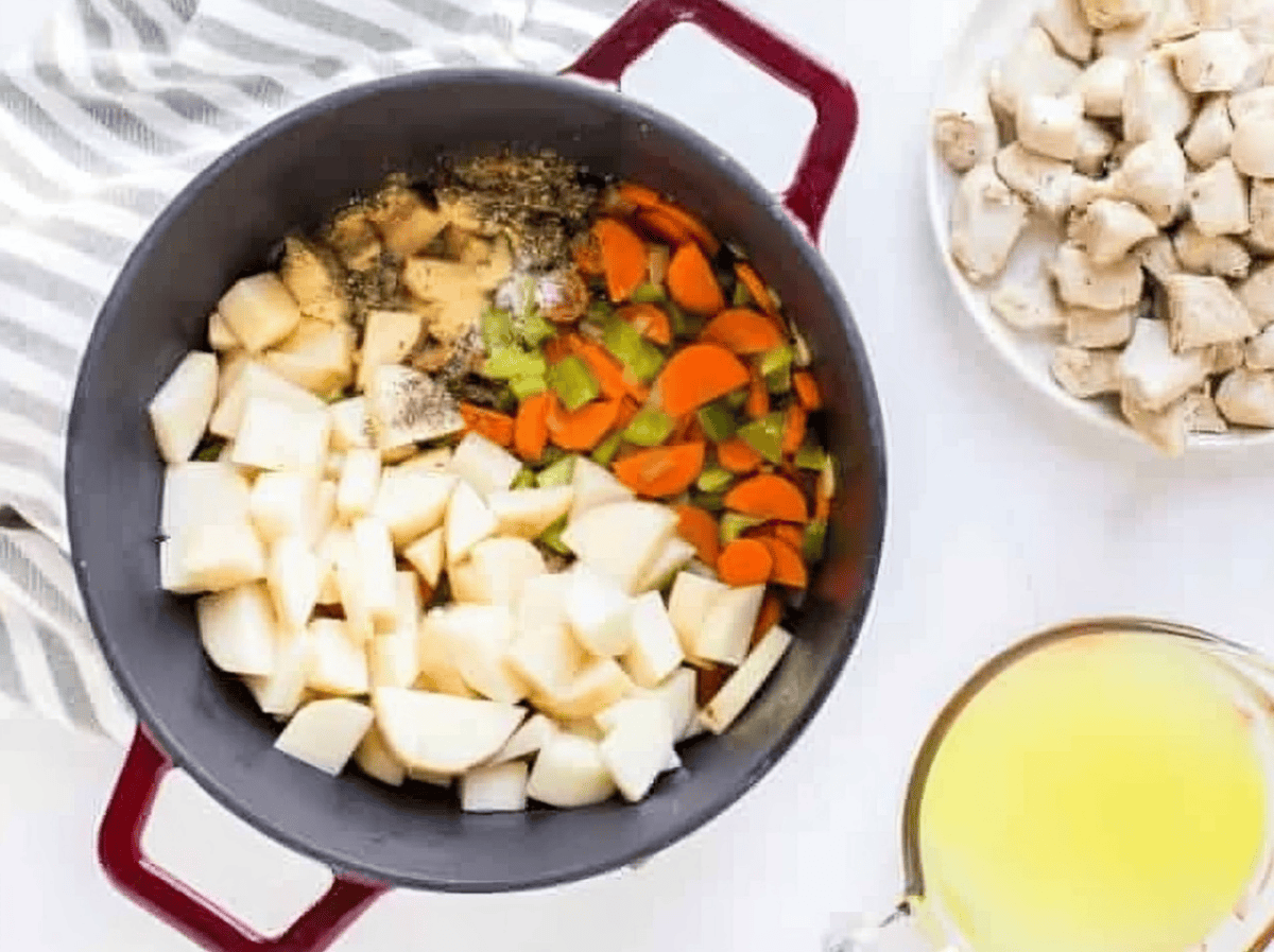 Chopped veggies and potatoes in a pot.