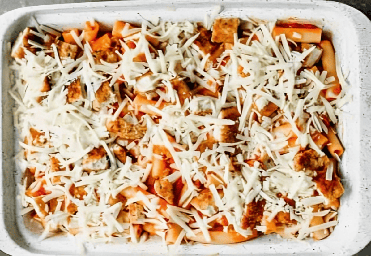 Chicken and ziti topped with shredded cheese.