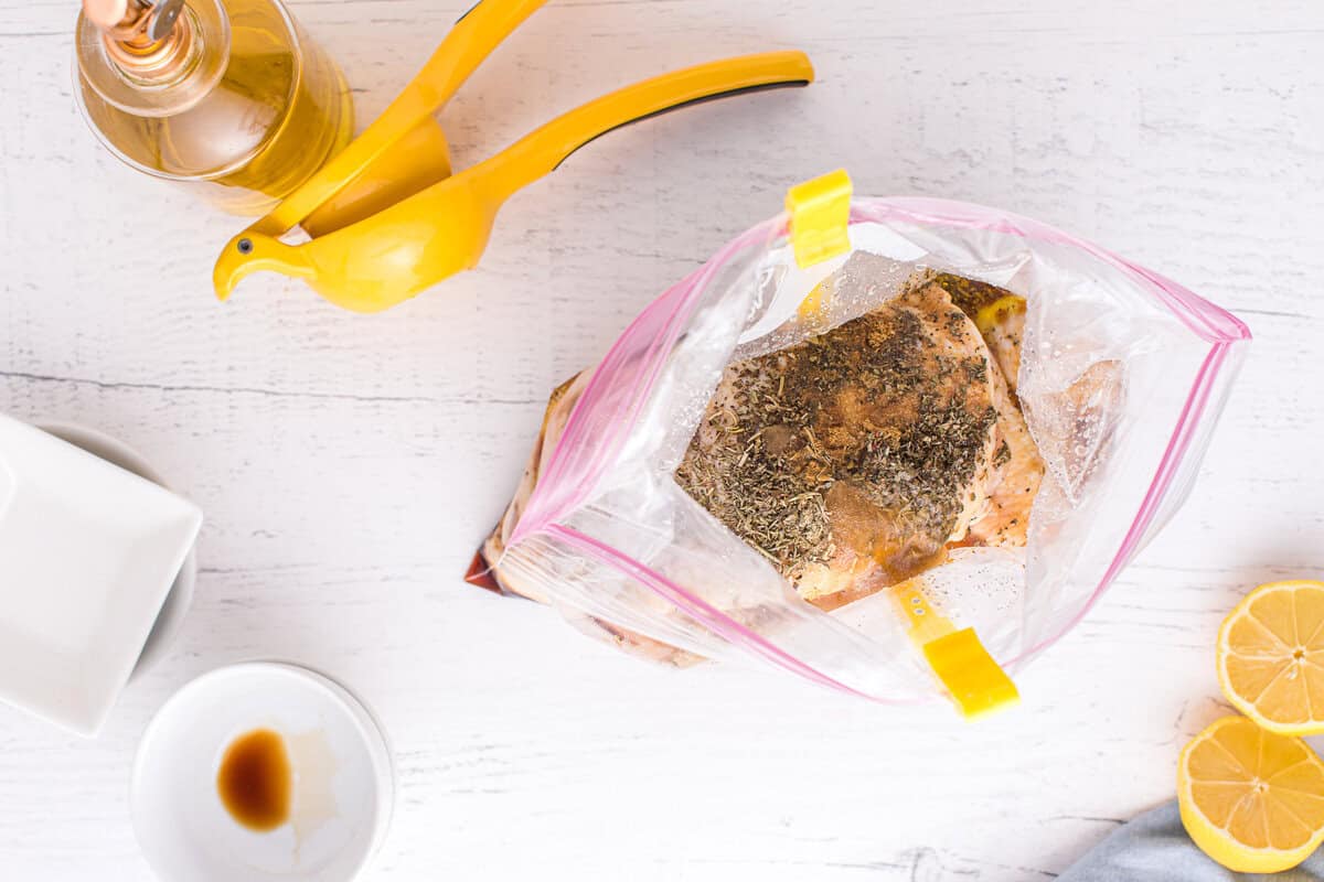 Seasoned chicken thighs sitting in a resealable bag to marinate.