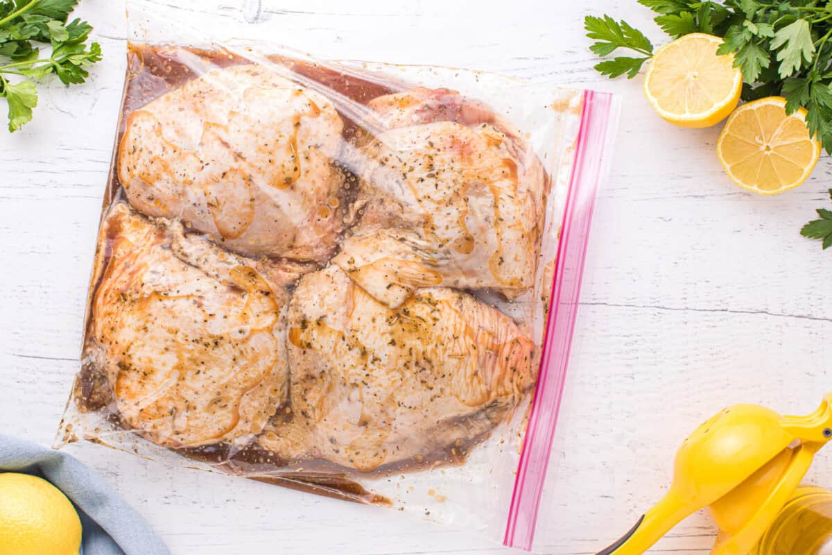 Chicken thighs marinating in a resealable bag.