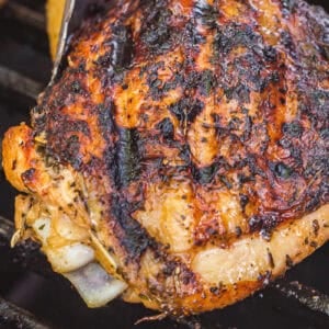 Cooking chicken thighs on a grill.