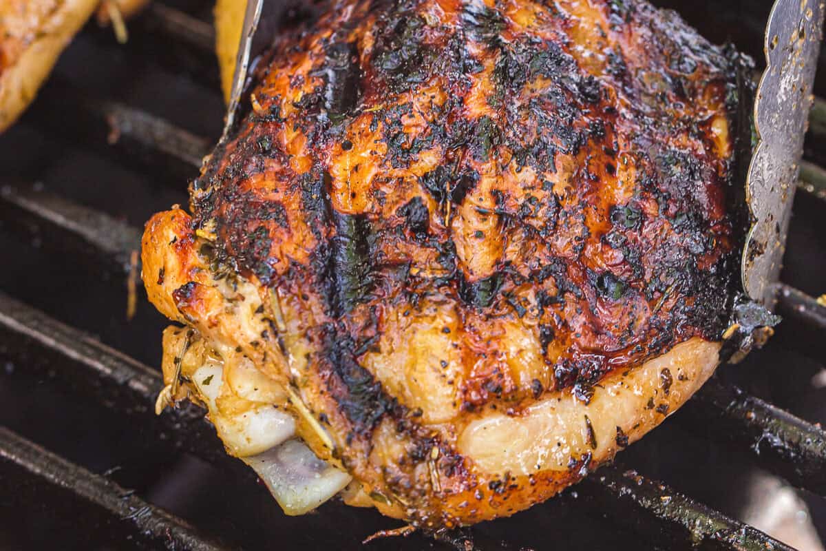 Cooking chicken thighs on a grill.