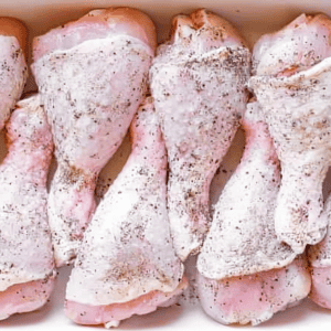 Raw chicken drumsticks coated with spices.