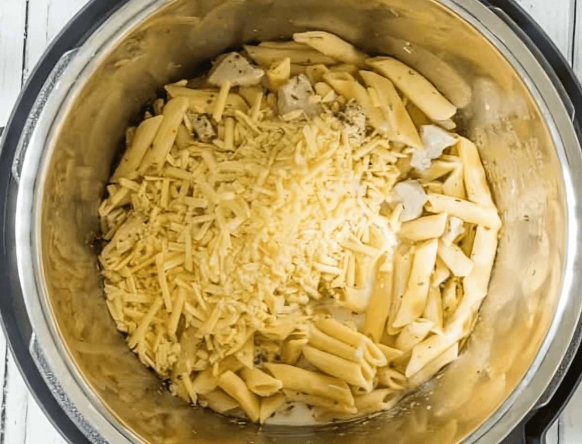 Shredded cheese on top of chicken pasta in an Instant Pot.