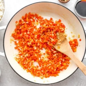 diced veggies in a pan with a wooden spoon.