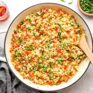 fried rice in a pan with a wooden spoon.