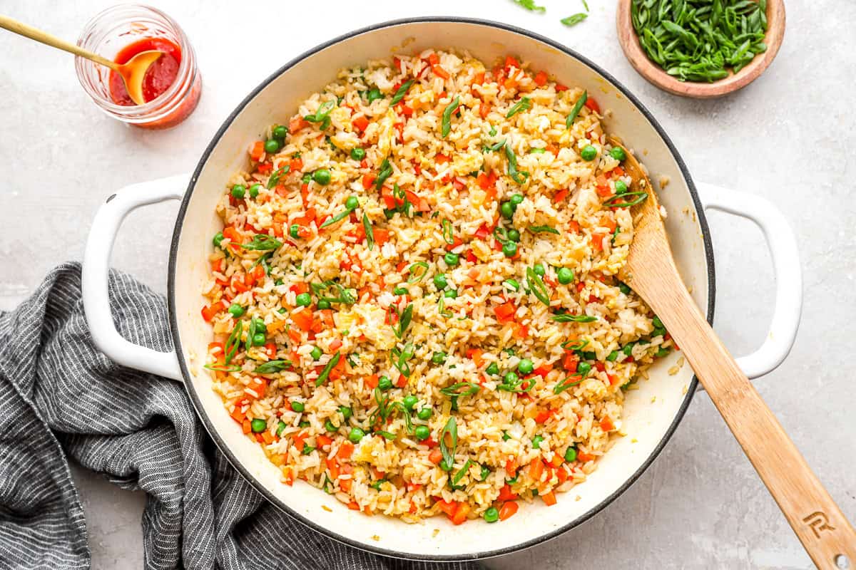 fried rice in a pan with a wooden spoon.