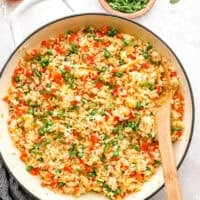 overhead view of fried rice in a pan with a wooden spoon.