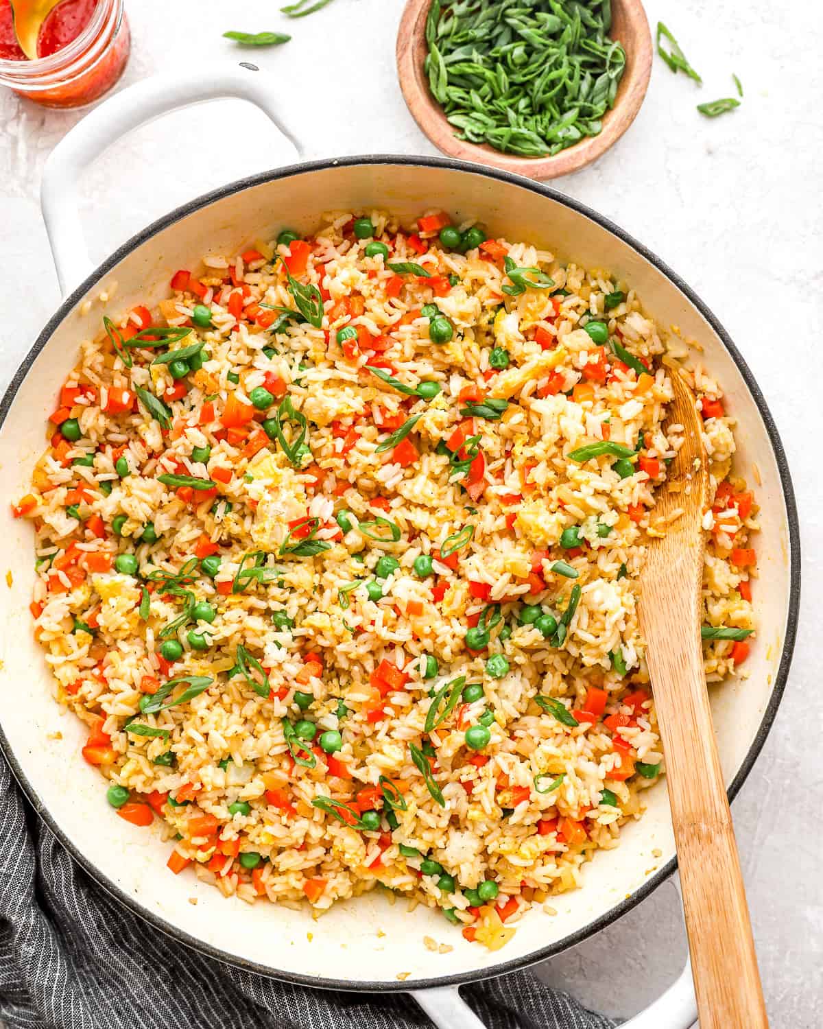 overhead view of fried rice in a pan with a wooden spoon.