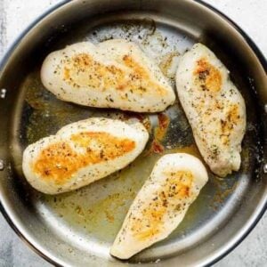 searing chicken breasts in a pan.