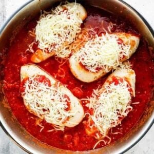 chicken marinara topped with shredded cheese in a pan.