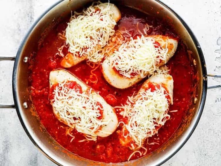 chicken marinara topped with shredded cheese in a pan.