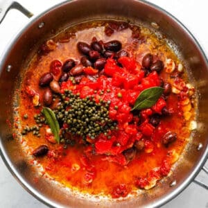 puttanesca sauce ingredients in a sauté pan.