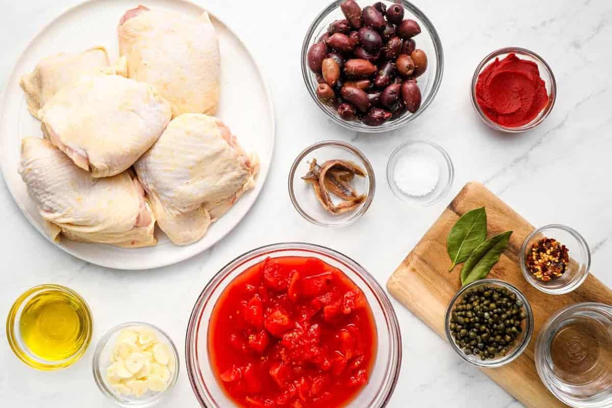 portioned ingredients for chicken puttanesca in individual containers.