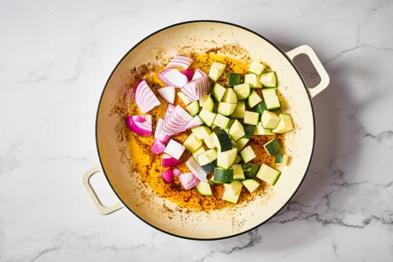 chopped zucchini and red onion in a skillet.