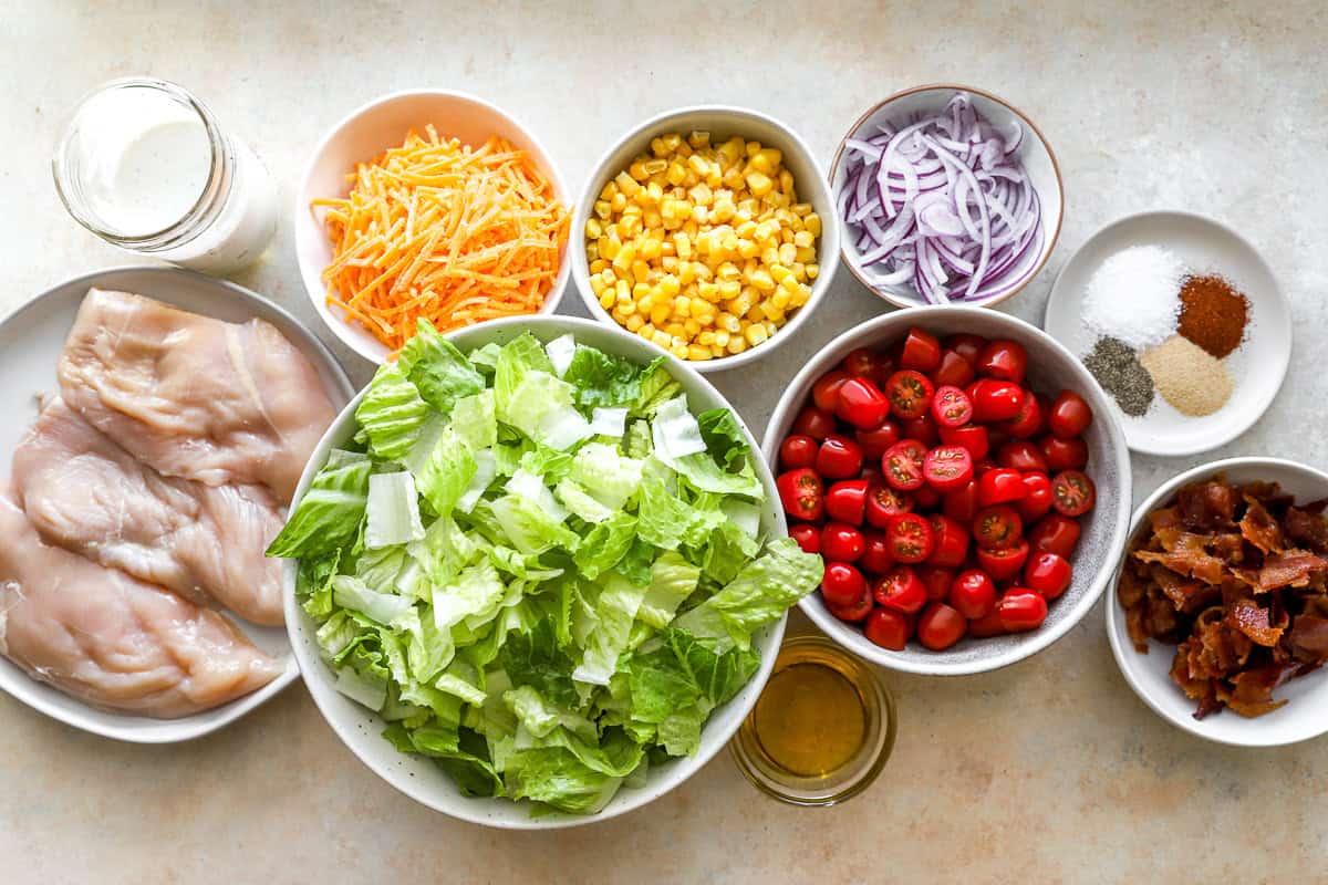 portioned and prepped ingredients for chopped chicken salad in individual bowls.