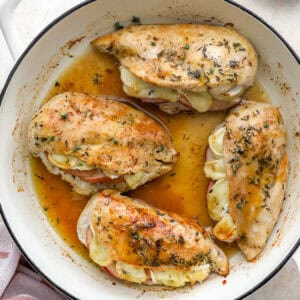 overhead view of apple brie stuffed chicken with maple glaze in a pan.