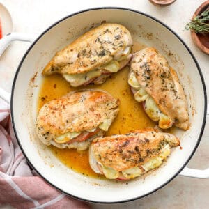 overhead view of saucy apple brie stuffed chicken breasts in a pan.