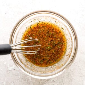 seasoned oil in a glass bowl with a whisk.