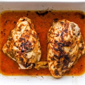 seasoned baked bone in chicken breasts in a baking dish.