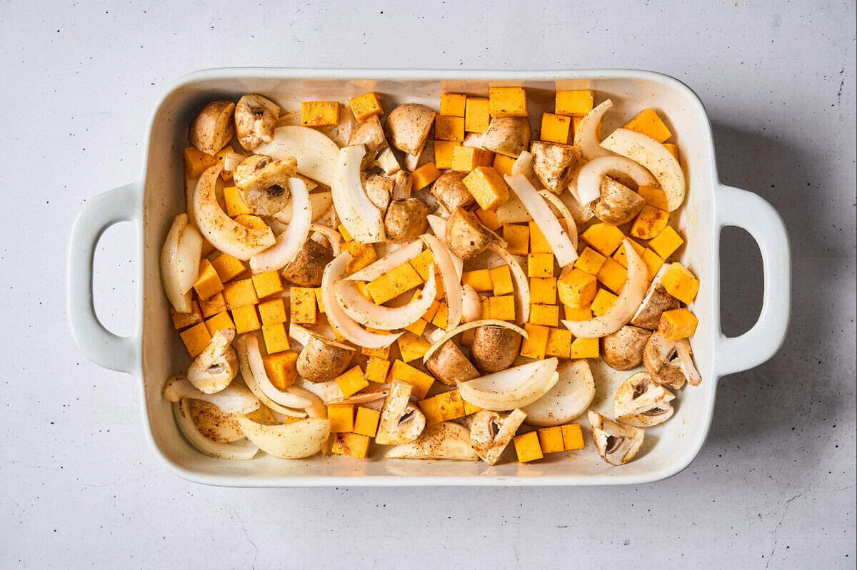 tossed seasoned thick-sliced onion, quartered mushrooms, and cubed butternut squash in a baking dish.