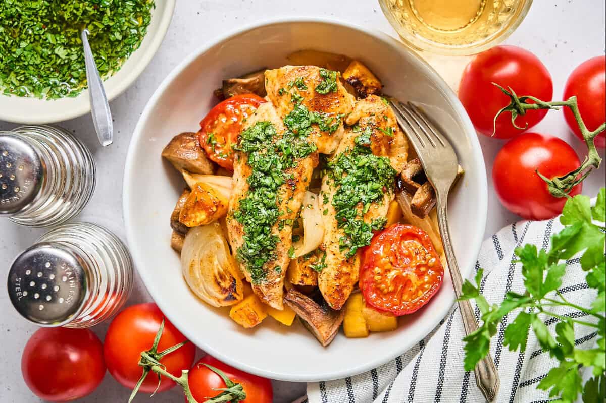 A serving of roasted chicken tenders and veggies in a bowl.
