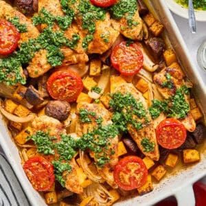 overhead view of askew sheet pan chicken tenders and veggies with hot honey chimichurri.