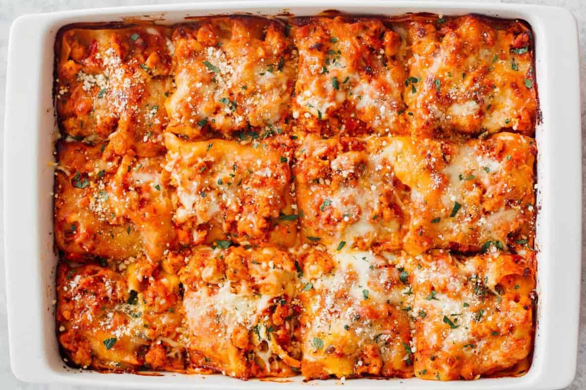 overhead view of a cut chicken lasagna in a baking dish.