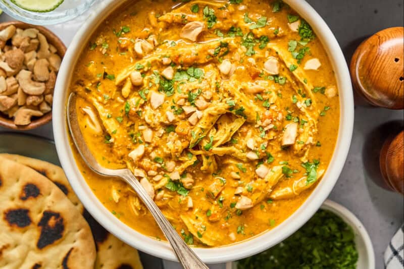 overhead view of a bowl of chicken mulligatawny soup with a spoon.