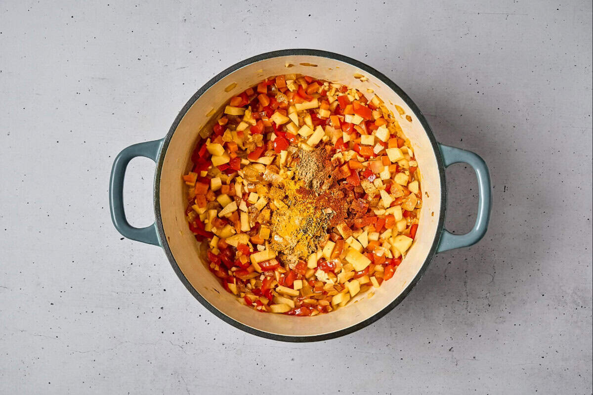 adding spices to sautéed vegetables in a dutch oven.