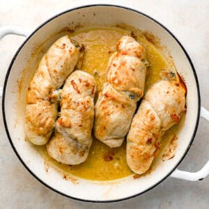 four roasted chicken roulades in an oven-safe pan.