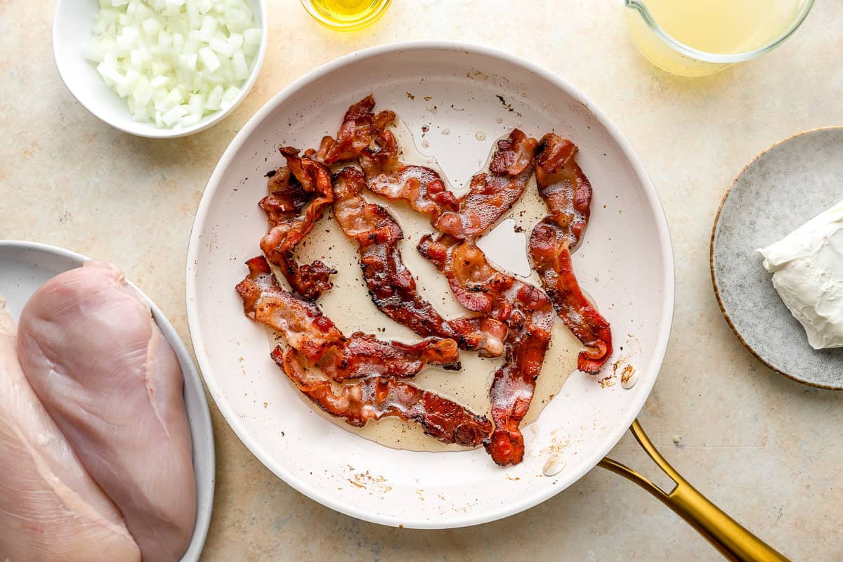 frying bacon slices in a frying pan.