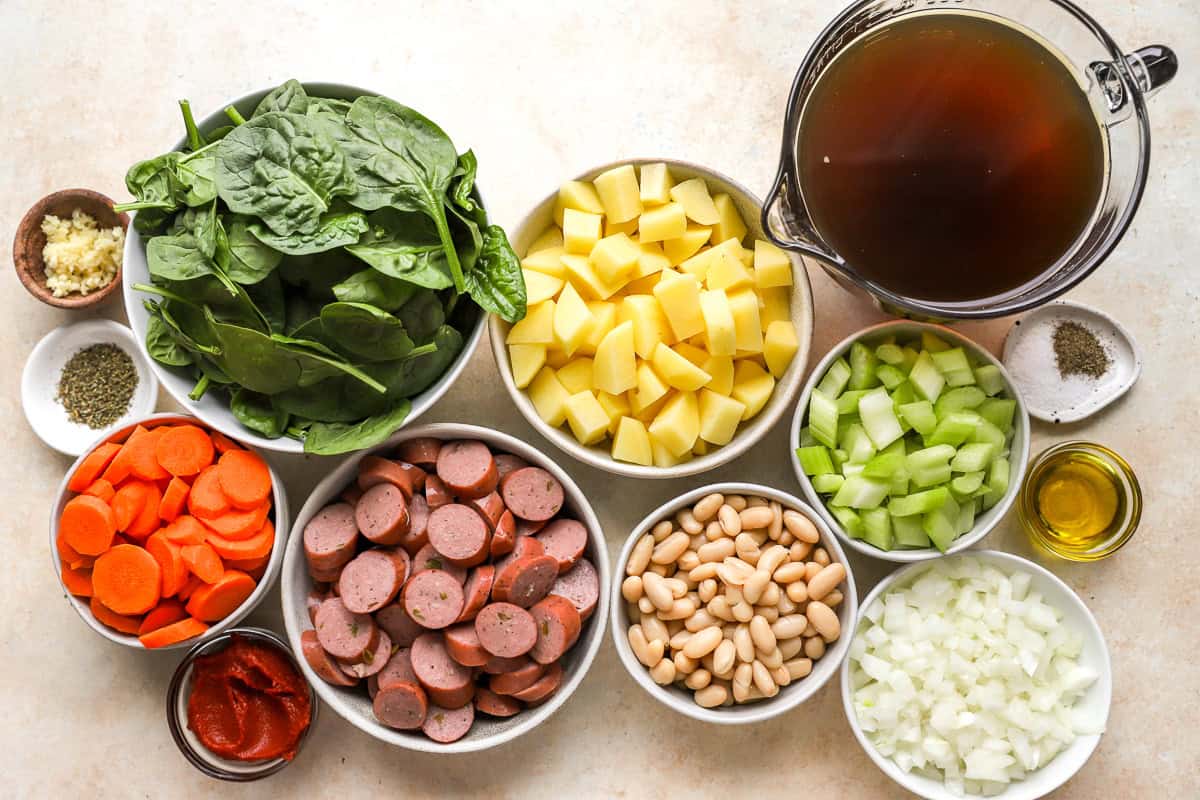portioned and prepped ingredients for chicken sausage stew in individual containers.