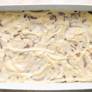 cream of chicken soup mixture poured evenly over raw seasoned chicken pieces in a casserole dish.