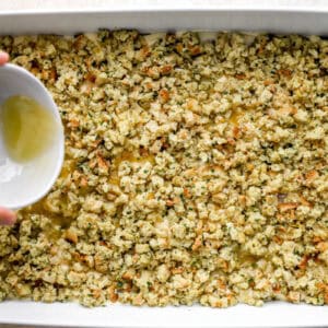 drizzling melted butter over chicken stuffing casserole in a baking dish before baking.