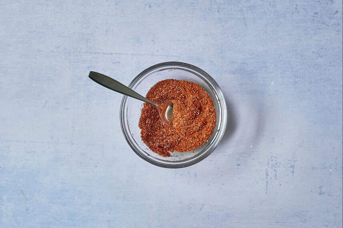 Chipotle spice mix in a glass bowl with a spoon.
