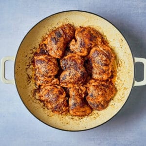 seared chipotle orange chicken thighs in a dutch oven.