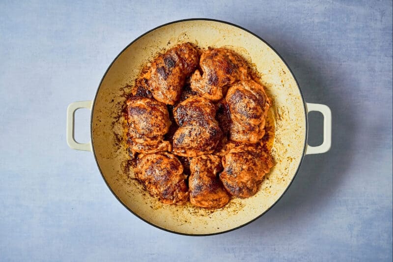 seared chipotle orange chicken thighs in a dutch oven.