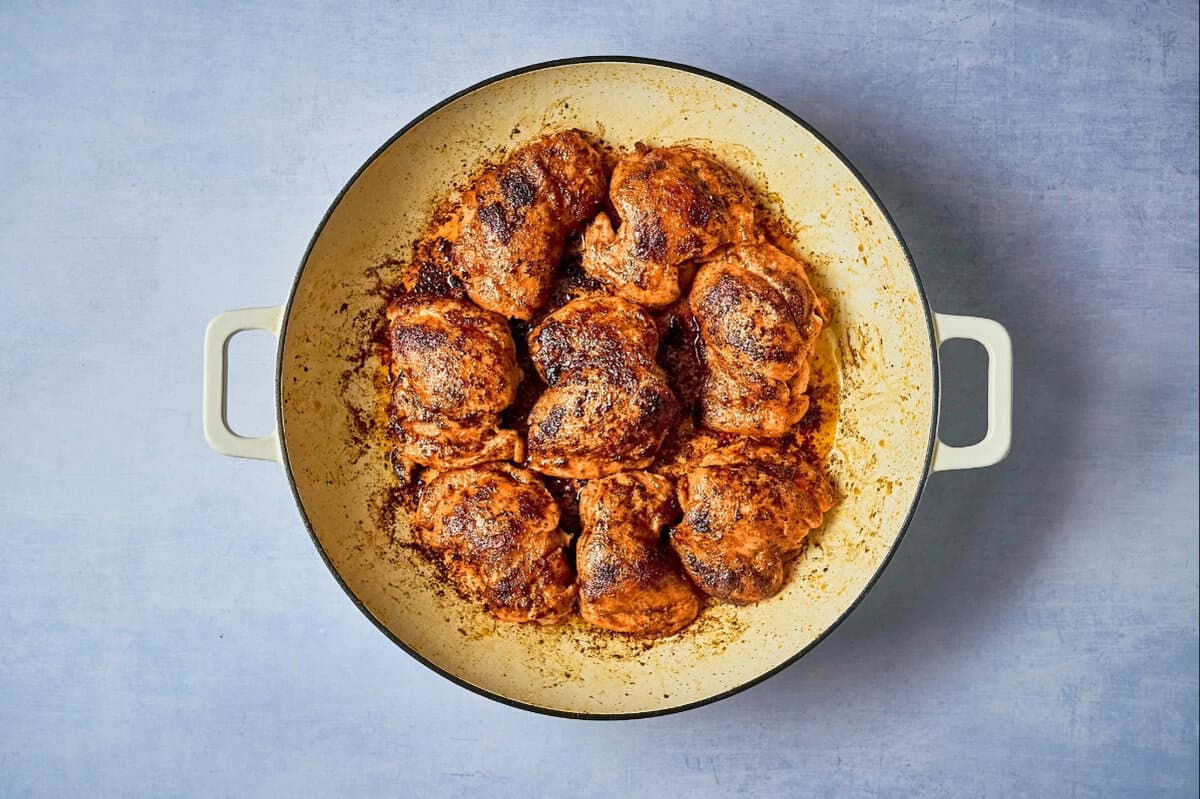 Seared chipotle chicken thighs in a pan.